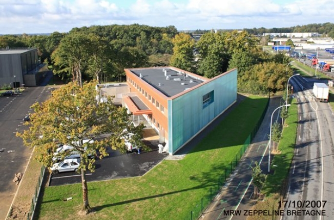 Bâtiment de la JA situé dans un espace vert proche d'une petite route