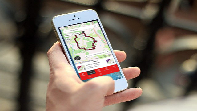 Une personne tient son mobile en main et consulte openrunner