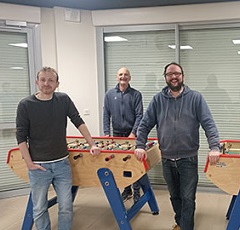 3 joueurs posant devant le babyfoot