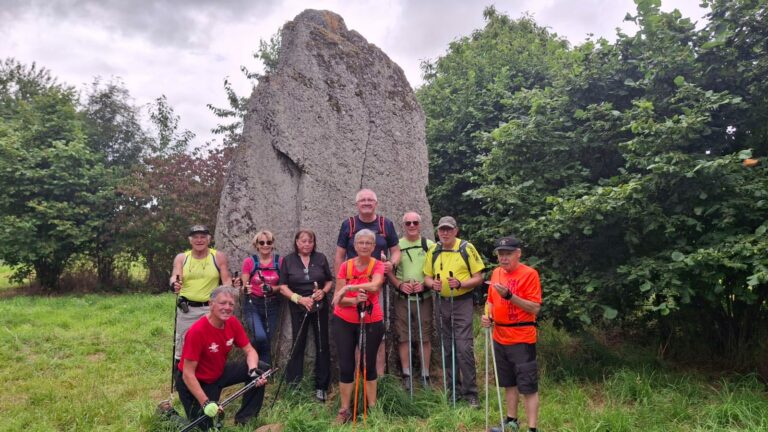 Le groupe des marcheurs posant devant un menhir