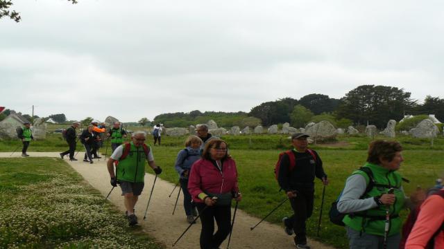 Marcheurs avec menhirs de Carnac en arrière plan